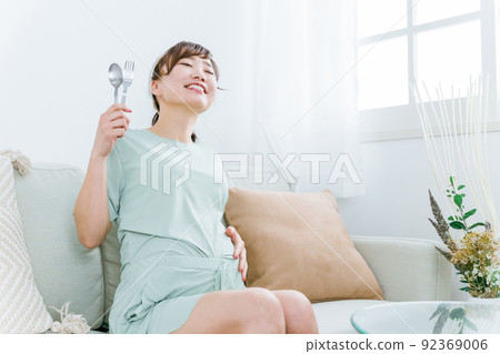 Japanese pregnant woman with spoon and fork (gluttony / meal) Japanese pregnant woman with spoon and fork (gluttony / meal) 92369006