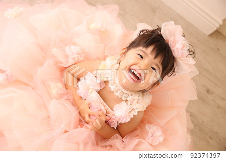 A smiling girl in a dress and looking up A smiling girl in a dress and looking up 92374397