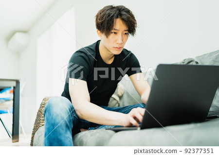 Young man working in the living room 92377351