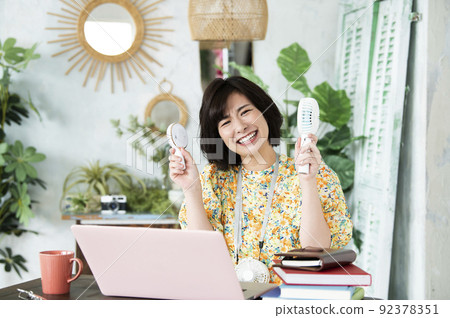 看著相機苦笑的女性遠程辦公省電移動風扇 92378351