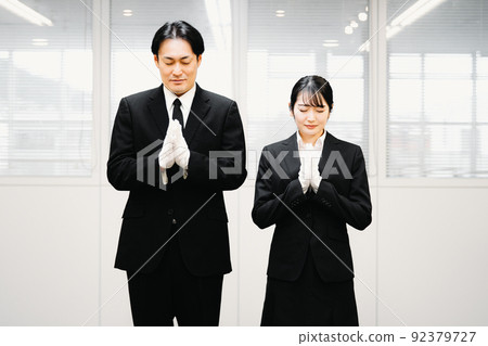 Men and women in formal wear wearing white gloves to join hands (funeral director, ceremonial occasion) 92379727