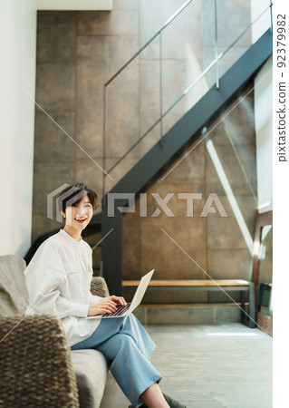 A woman teleworking in a fashionable living room A woman teleworking in a fashionable living room 92379982