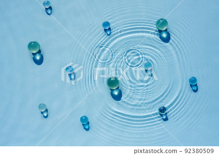 Abstract background, texture of blue water with round ripples with transparent balls, capsules 92380509