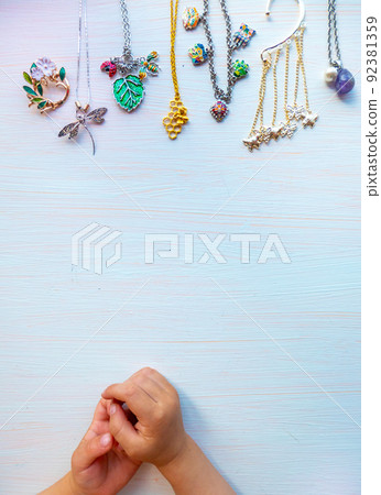 childrens hands play with light summer bijouterie, on white background. concept of womens happines. Copy space childrens hands play with light summer bijouterie, on white background. concept of womens happines. Copy space 92381359
