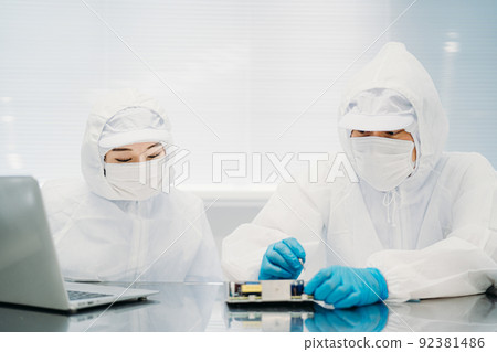 Female handling precision equipment in a clean room 92381486