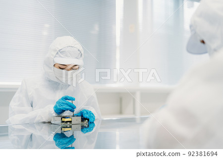 Female handling precision equipment in a clean room 92381694