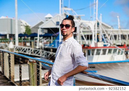 Hispanic man wearing sunglasses and the Australian sea Hispanic man wearing sunglasses and the Australian sea 92382152