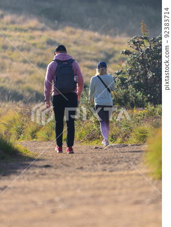 Couple trekking in the Horton plains national park in the morning. Couple trekking in the Horton plains national park in the morning. 92383714