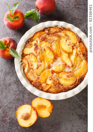 Close up of fresh organic peaches and delicious peach Cobbler baked in a ceramic dish. Vertical top view 92386461
