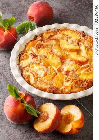 Close up of fresh organic peaches and delicious peach Cobbler baked in a ceramic dish. Vertical Close up of fresh organic peaches and delicious peach Cobbler baked in a ceramic dish. Vertical 92386466
