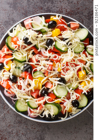 Serbian salad called sopska salata with vegetables and cheese closeup in the plate. Vertical top view 92386471