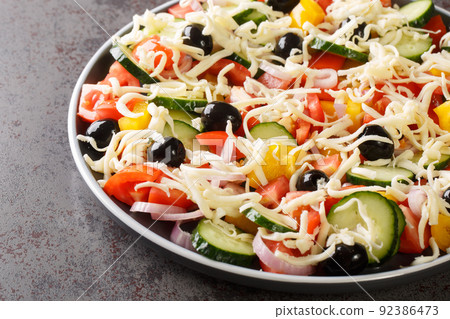 Tasty Shopska or sopska salata with vegetables and cheese closeup in the plate. Horizontal 92386473