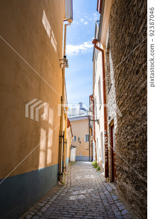 Empty cobbled alley amidst residential buildings in old town at city against sky Empty cobbled alley amidst residential buildings in old town at city against sky 92387046