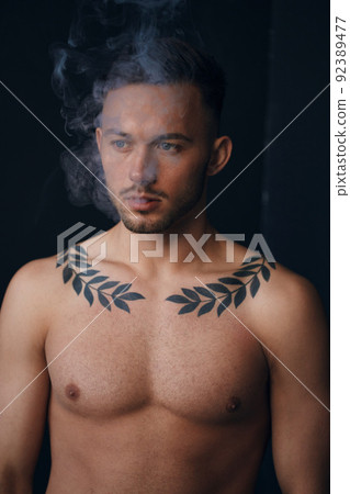 Modelling snapshots. Pensive serious tanned attractive handsome naked man thinking looks aside smoking posing isolated in black studio background. Fashion offer. Copy space for ad. Closeup 92389477
