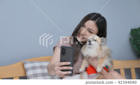 Holiday concept of 4k Resolution. Asian girls playing cell phones in the bedroom. Take a picture with a smartphone. Holiday concept of 4k Resolution. Asian girls playing cell phones in the bedroom. Take a picture with a smartphone. 92394690