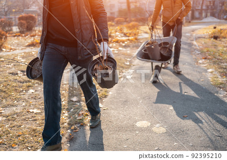 reforestation or man carrying young tree sapling in pots for planting in yard reforestation or man carrying young tree sapling in pots for planting in yard 92395210