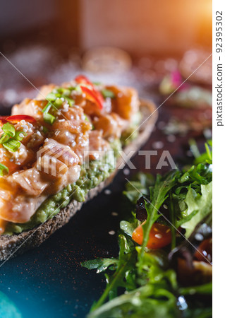 fresh sandwich with avocado, red salmon fish, arugula, tomato, salad, green fresh sandwich with avocado, red salmon fish, arugula, tomato, salad, green 92395302