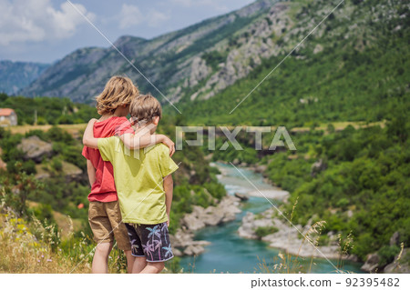 boys, friends tourists on background of purest waters of the turquoise color of the river Moraca flowing among the canyons. Travel around Montenegro concept Portrait of a disgruntled girl sitting at a boys, friends tourists on background of purest waters of the turquoise color of the river Moraca flowing among the canyons. Travel around Montenegro concept Portrait of a disgruntled girl sitting at a 92395482