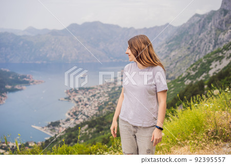 Woman tourist enjoys the view of Kotor. Montenegro. Bay of Kotor, Gulf of Kotor, Boka Kotorska and walled old city. Travel to Montenegro concept. Fortifications of Kotor is on UNESCO World Heritage Woman tourist enjoys the view of Kotor. Montenegro. Bay of Kotor, Gulf of Kotor, Boka Kotorska and walled old city. Travel to Montenegro concept. Fortifications of Kotor is on UNESCO World Heritage 92395557