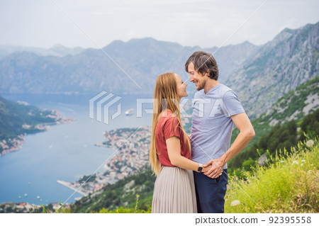 Man and woman couple tourists enjoying the view of Kotor. Montenegro. Bay of Kotor, Gulf of Kotor, Boka Kotorska and walled old city. Travel to Montenegro concept. Fortifications of Kotor is on UNESCO Man and woman couple tourists enjoying the view of Kotor. Montenegro. Bay of Kotor, Gulf of Kotor, Boka Kotorska and walled old city. Travel to Montenegro concept. Fortifications of Kotor is on UNESCO 92395558