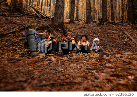 Portrait of a family sitting down to rest during a hike in the mountains. 92396120