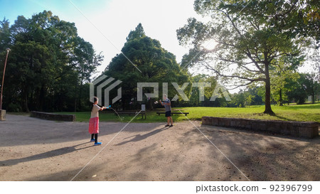 Parents and children playing in the water in a summer park Parents and children playing in the water in a summer park 92396799