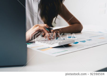 Close up hand of woman entrepreneur using a calculator to calculating financial expense. accounting financial concept. 92398504