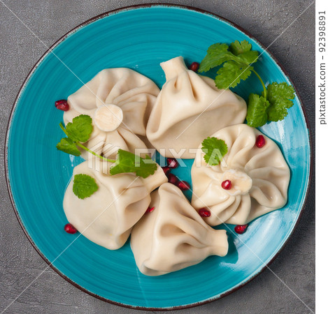 traditional Georgian dish khinkali decorated with pomegranate and cilantro 92398891