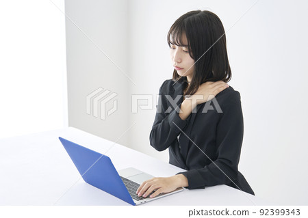 Business woman who feels stiff shoulders at desk work Business woman who feels stiff shoulders at desk work 92399343