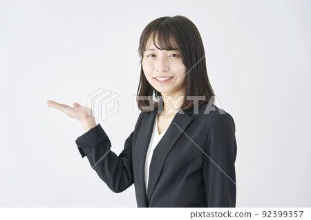 Business woman pointing to the right side with her palm on a white background Business woman pointing to the right side with her palm on a white background 92399357