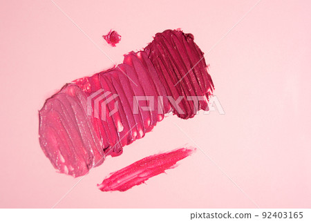 Swatches of shimmery shades of red and pink lipstick. Texture of decorative cosmetics Swatches of shimmery shades of red and pink lipstick. Texture of decorative cosmetics 92403165