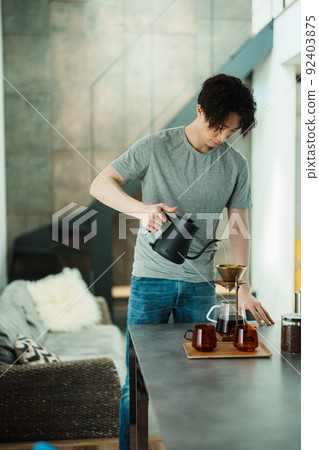 一個年輕人沖泡咖啡 92403875