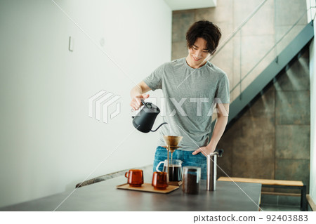 一個年輕人沖泡咖啡 92403883