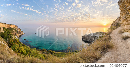 panorama on sunset time with beautiful clouds in the rocky bay with crystal clear azure sea on a sunny day. The concept of an ideal place for summer travel and relaxation. 92404077
