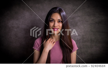 Pretty Asian woman - portrait shot against grey background Pretty Asian woman - portrait shot against grey background 92404684