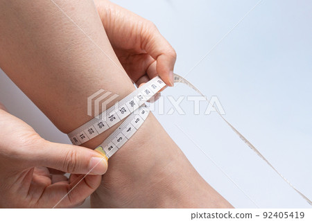Measure the circumference of a body part with a tape measure Measure the circumference of a body part with a tape measure 92405419