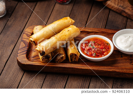 Spring rolls with salsa sauce and sour cream Spring rolls with salsa sauce and sour cream 92406310