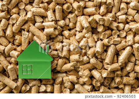 Small green house over wood pellets background. 92406503
