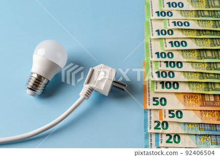 RRising energy prices. White electrical plug and light bulb at euro banknotes over blue background 92406504