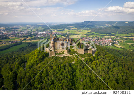 Hohenzollern Castle on forested mountain top in the Swabian Alps in summer Hohenzollern Castle on forested mountain top in the Swabian Alps in summer 92408351