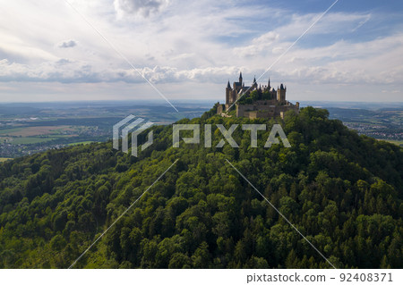 Hohenzollern Castle on forested mountain top in the Swabian Alps in summer Hohenzollern Castle on forested mountain top in the Swabian Alps in summer 92408371
