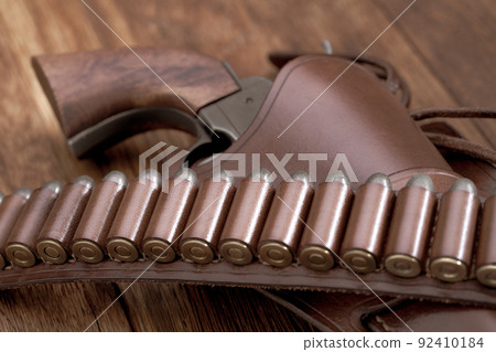 Old west leather gun belt with ammnunition and revolver in holster Old west leather gun belt with ammnunition and revolver in holster 92410184