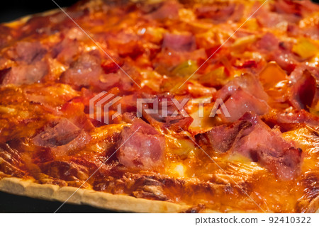 Burnt homemade pizza on tray in electric oven: macro, close up 92410322