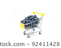 small shopping cart full of fresh blueberry isolated. selective focus 92411428