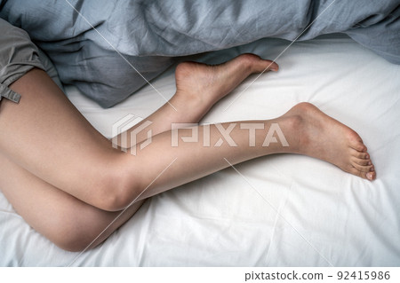 Bare feet of a woman sleeping in bed Bare feet of a woman sleeping in bed 92415986