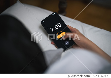 A woman who stops the alarm on her smartphone 92416013