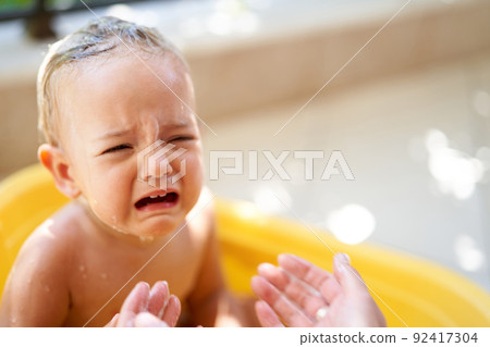 Little girl crying in a bowl of water Little girl crying in a bowl of water 92417304