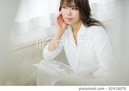 Woman reading a magazine at home - Stock Photo [92418079] - PIXTA