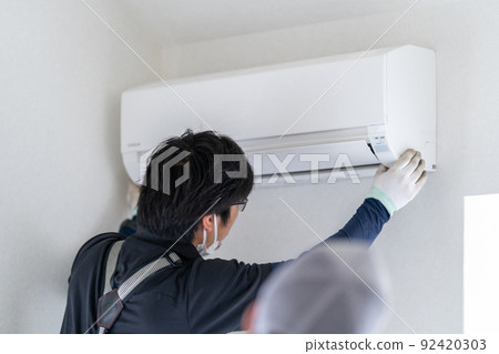 Air conditioner installation work: Hook the indoor unit on the installation plate and install it on the wall Air conditioner installation work: Hook the indoor unit on the installation plate and install it on the wall 92420303