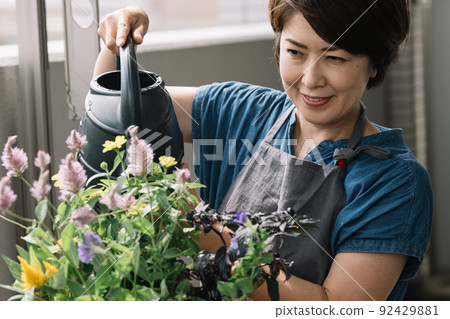 A woman doing group planting, gardening, and watering flowers A woman doing group planting, gardening, and watering flowers 92429881